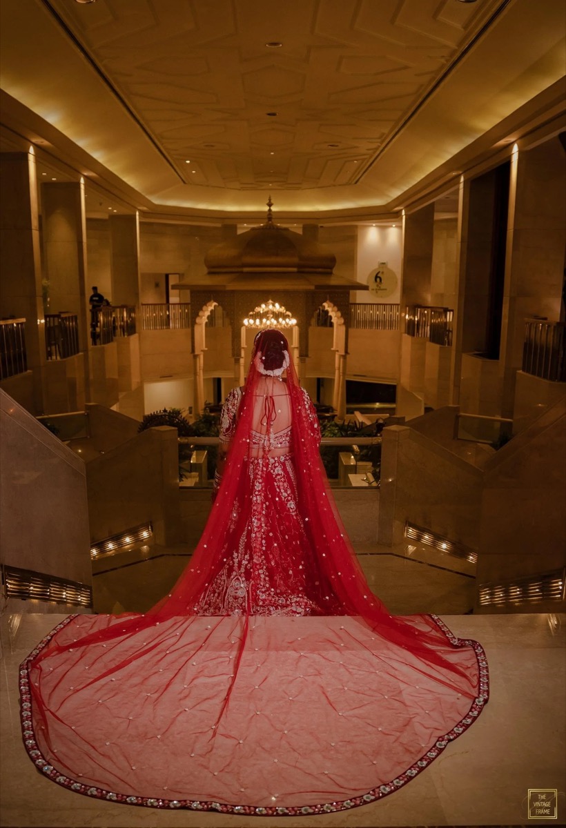 Bride in a red and gold bridal lehenga with veil styled by Shreya Gupta Kedia